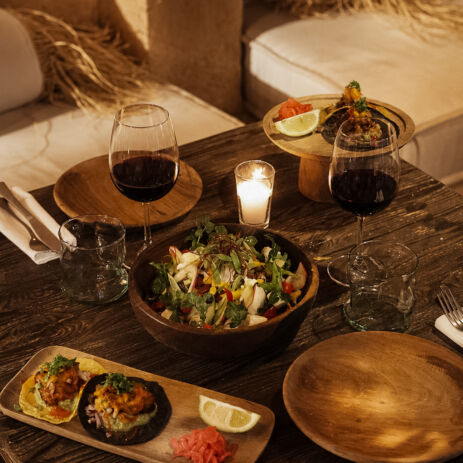 Salade, tacos et verres de vin rouge sur table en bois, dîner à la bougie chez AZULIK I INLA, Marrakech
