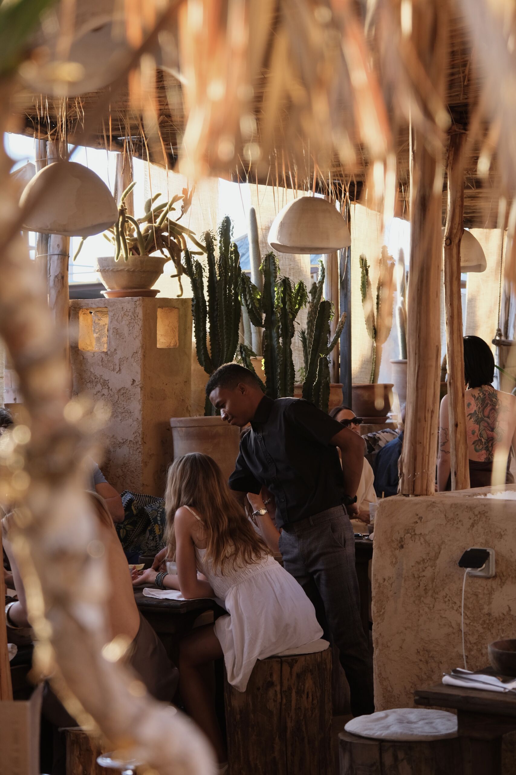 Convives attablés sous les palmes au patio d'AZULIK I INLA, dîner dans la médina de Marrakech
